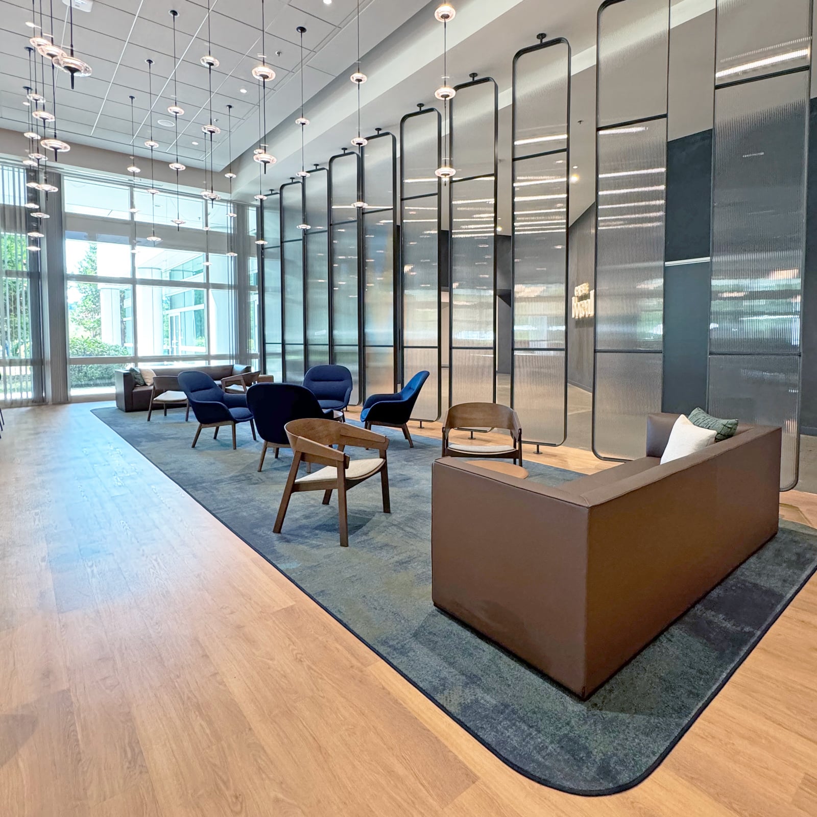 Commercial lobby lounge with fluted glass partitions and pendant lighting
